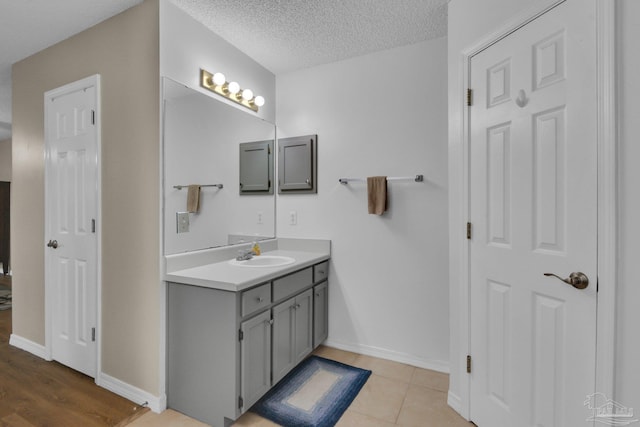 bathroom with vanity, tile patterned flooring, and a textured ceiling