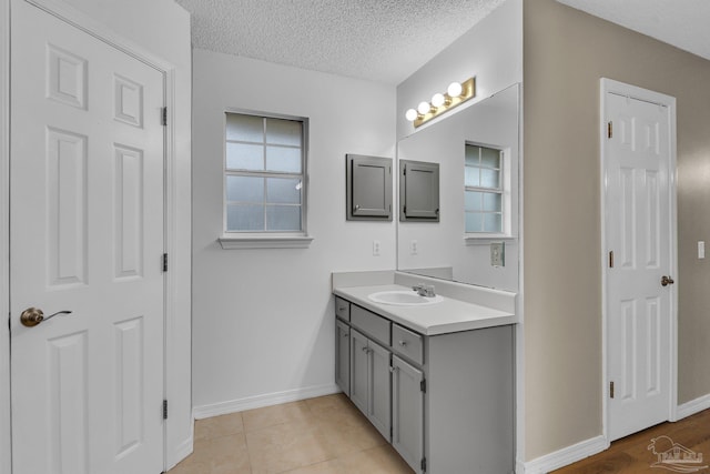 bathroom with a textured ceiling, tile patterned flooring, and vanity