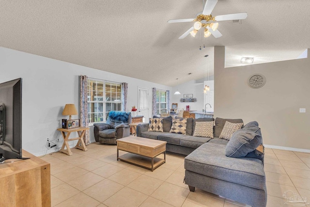 living room with ceiling fan, light tile patterned flooring, a textured ceiling, and vaulted ceiling