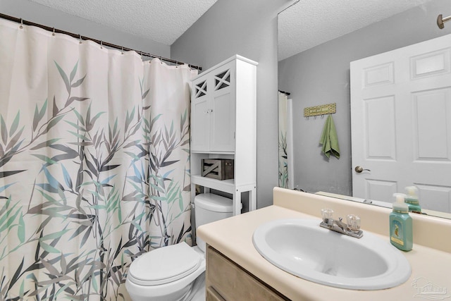 bathroom with toilet, vanity, and a textured ceiling