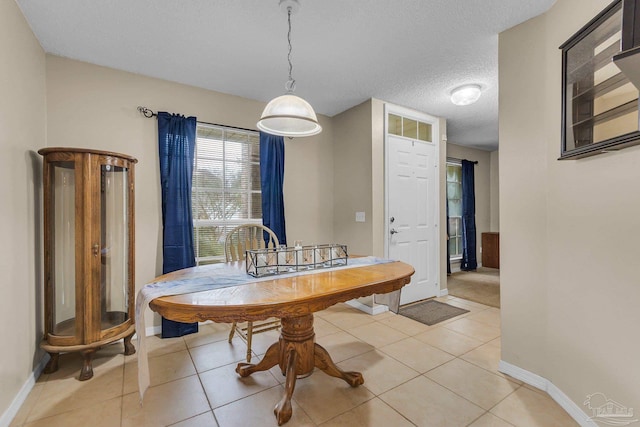 dining space featuring a textured ceiling and light tile patterned floors