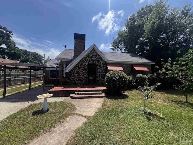 view of front of property featuring a chimney, fence, stone siding, and a front yard