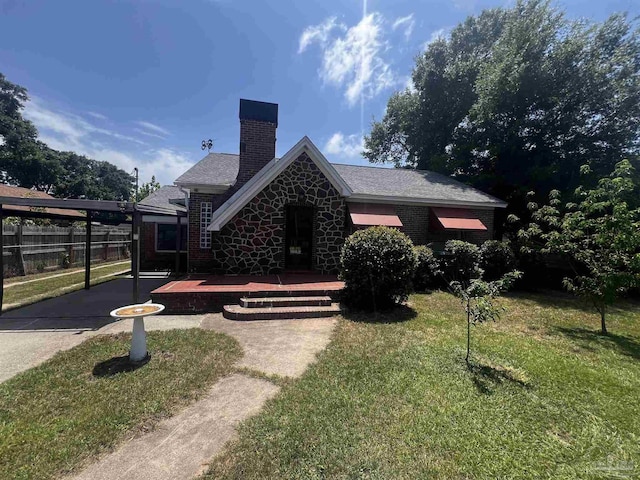 view of front of property featuring fence, a chimney, a carport, and a front lawn
