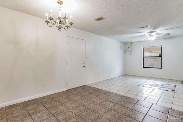 spare room featuring a textured ceiling, light tile patterned floors, and ceiling fan with notable chandelier