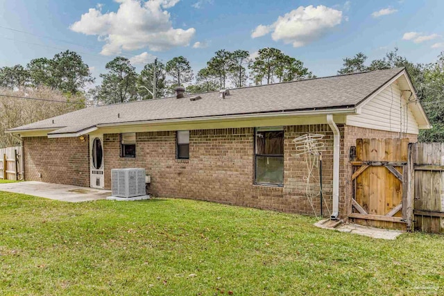 back of property with cooling unit, a yard, and a patio area