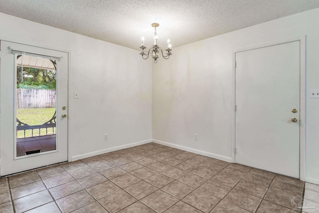 interior space featuring a notable chandelier, a textured ceiling, and light tile patterned floors