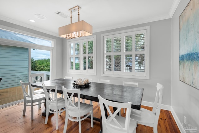 dining space featuring an inviting chandelier, hardwood / wood-style floors, and ornamental molding