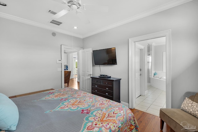 bedroom featuring ornamental molding, ensuite bathroom, ceiling fan, and light wood-type flooring