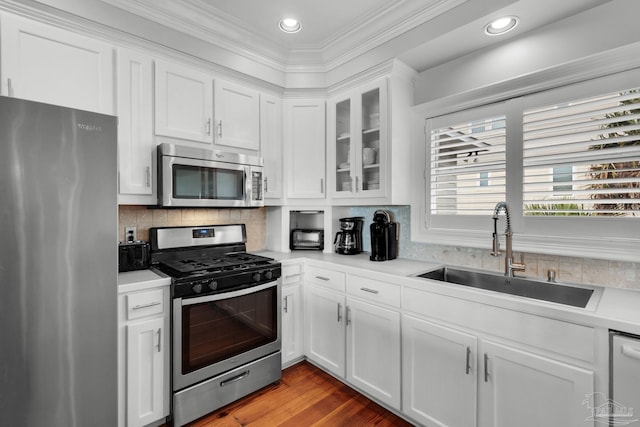 kitchen featuring stainless steel appliances, white cabinetry, sink, and backsplash