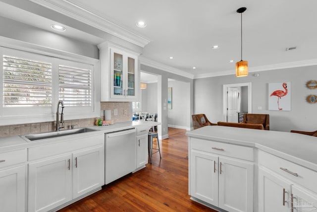 kitchen featuring dishwasher, sink, white cabinets, and decorative light fixtures