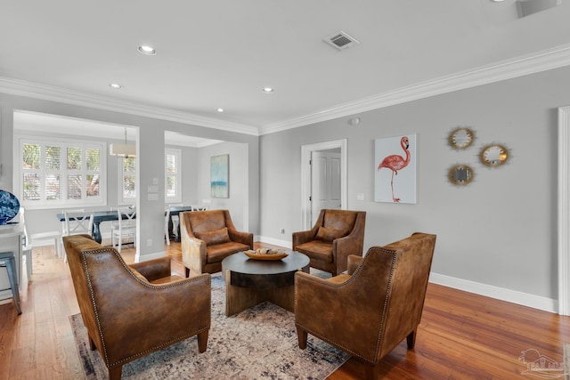 living room with crown molding and hardwood / wood-style floors