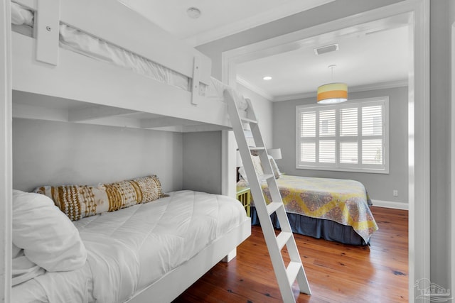 bedroom featuring crown molding and wood-type flooring