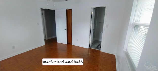 unfurnished bedroom with connected bathroom, baseboards, and visible vents