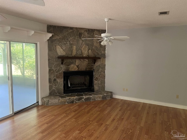 unfurnished living room with a textured ceiling, a fireplace, ceiling fan, and hardwood / wood-style flooring