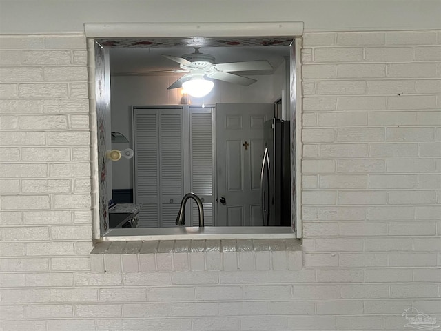 interior details featuring a ceiling fan and freestanding refrigerator