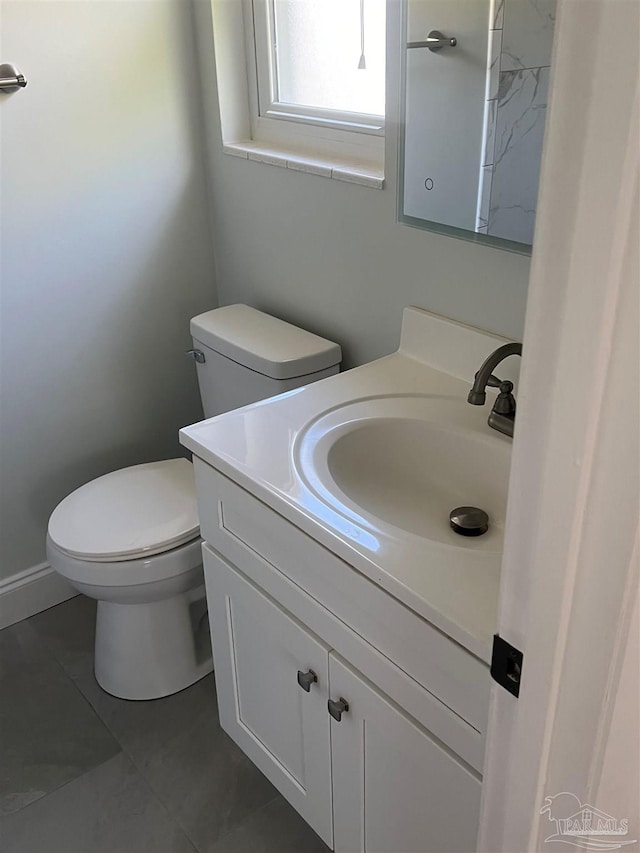 half bathroom with tile patterned floors, toilet, and vanity