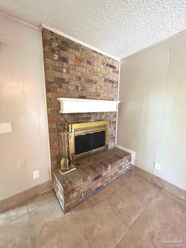 room details with tile patterned floors, ornamental molding, a fireplace, a textured ceiling, and wooden walls