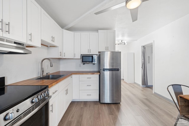 kitchen featuring sink, white cabinetry, light wood-type flooring, wooden counters, and appliances with stainless steel finishes