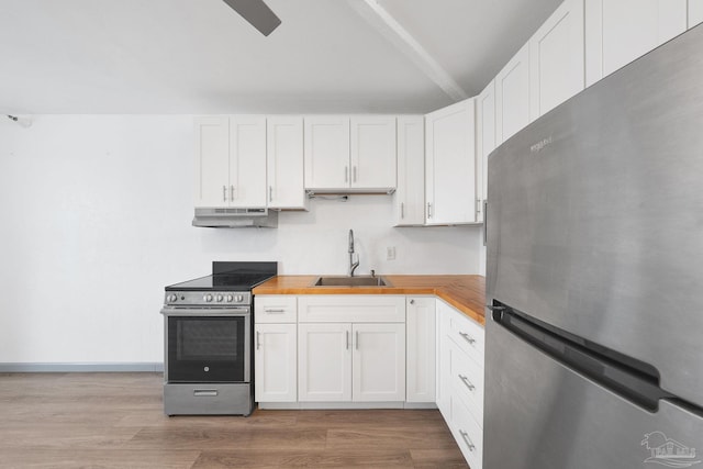 kitchen featuring sink, stainless steel appliances, white cabinetry, and butcher block countertops