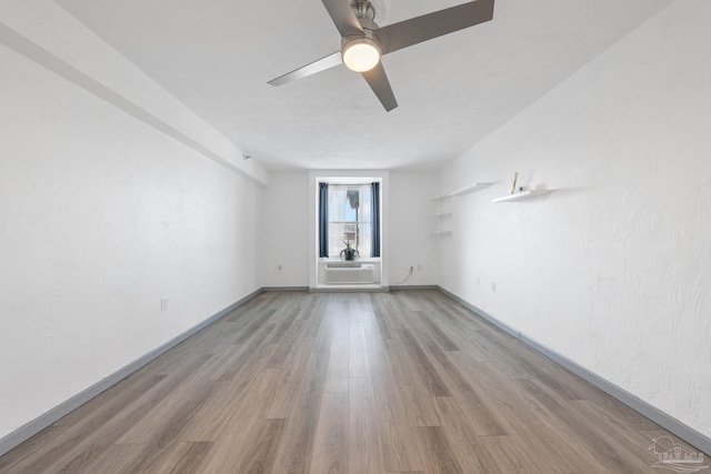 empty room with ceiling fan, light hardwood / wood-style floors, and cooling unit