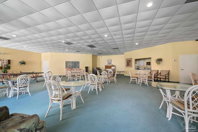 dining area featuring carpet and a drop ceiling