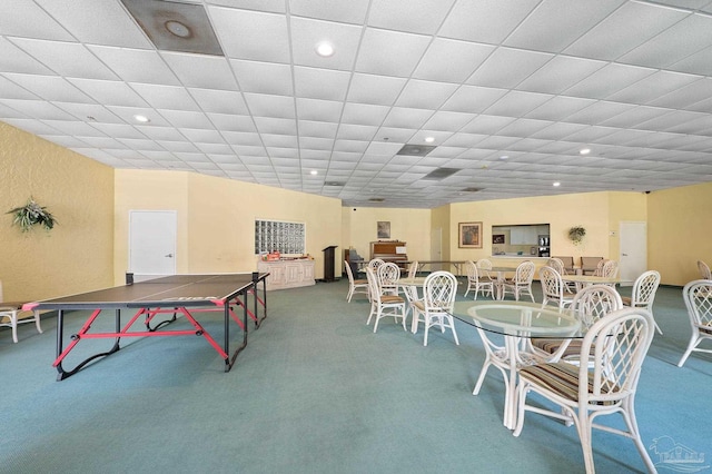 recreation room featuring a paneled ceiling and carpet flooring