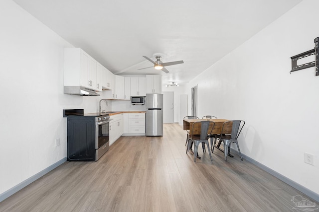 kitchen with light hardwood / wood-style floors, stainless steel appliances, ceiling fan, white cabinets, and sink