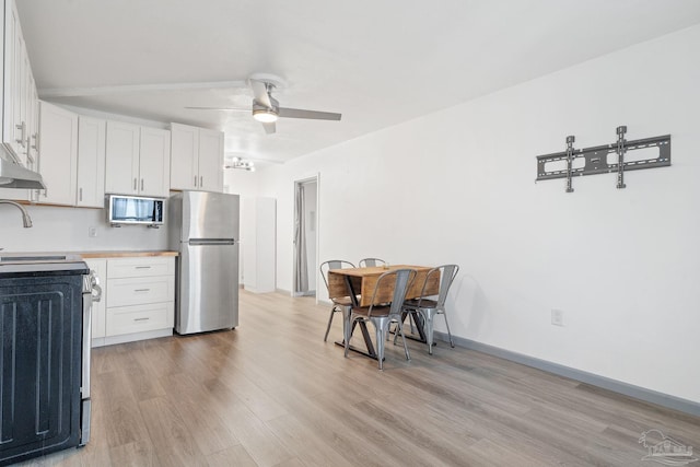 kitchen featuring white cabinets, light wood-type flooring, appliances with stainless steel finishes, and ceiling fan