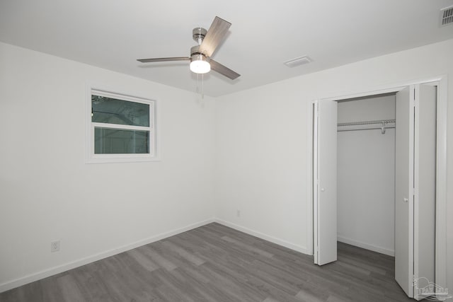 unfurnished bedroom with ceiling fan, hardwood / wood-style floors, and a closet