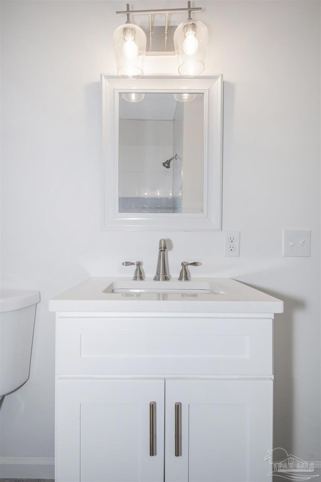 bathroom featuring vanity, toilet, and walk in shower