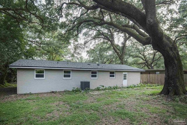 back of property with a yard and central AC unit