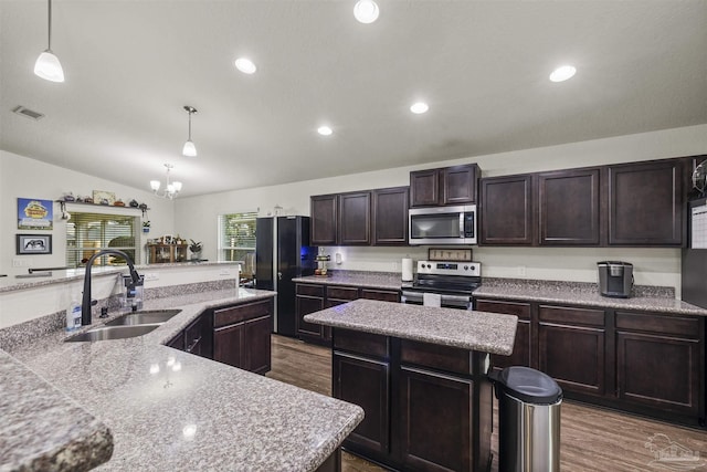 4327 Thistle Pine Ct, Pace, FL 32571 - kitchen featuring appliances with stainless steel finishes, a kitchen island with sink, vaulted ceiling, dark wood-style flooring, and a chandelier