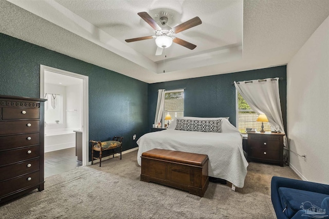 4327 Thistle Pine Ct, Pace, FL 32571 - carpeted bedroom featuring a textured wall, a raised ceiling, a textured ceiling, ensuite bathroom, and a ceiling fan