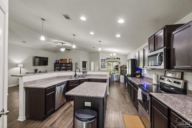 4327 Thistle Pine Ct, Pace, FL 32571 - kitchen featuring stainless steel appliances, a spacious island, dark wood finished floors, dark brown cabinetry, and a ceiling fan