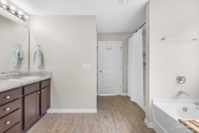 bathroom with vanity, hardwood / wood-style floors, and a tub