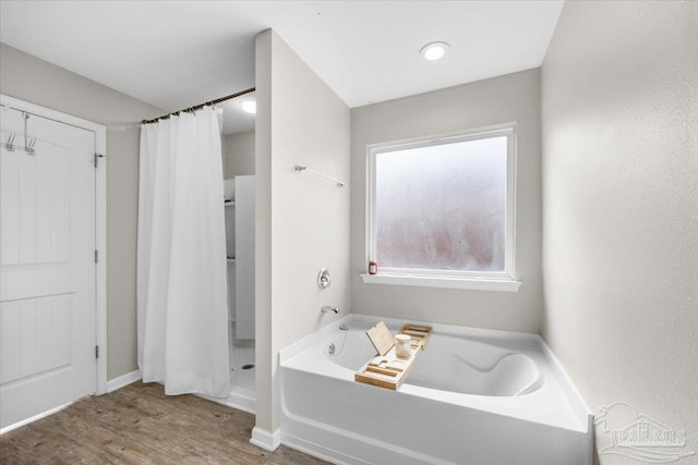 bathroom featuring plus walk in shower and hardwood / wood-style floors