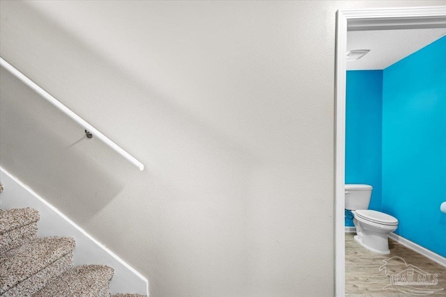 bathroom featuring wood-type flooring and toilet