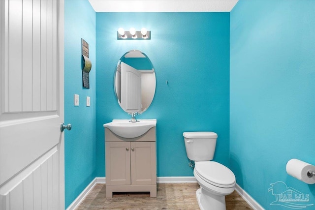 bathroom featuring vanity, wood-type flooring, and toilet