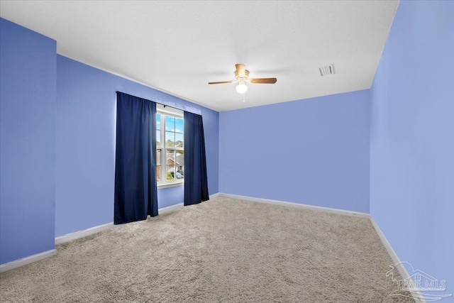 unfurnished room with ceiling fan and carpet flooring