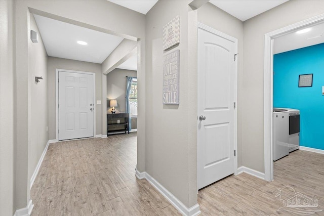 corridor featuring washer / clothes dryer and light hardwood / wood-style floors