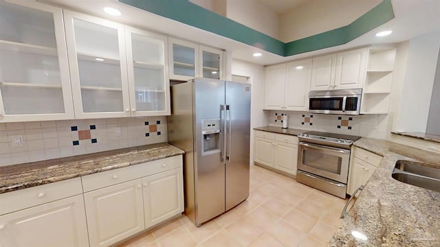 1129 Seabreeze Ln, Gulf Breeze, FL 32563 - kitchen featuring backsplash, white cabinets, stainless steel appliances, and light stone counters