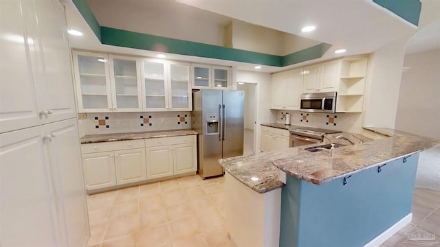 1129 Seabreeze Ln, Gulf Breeze, FL 32563 - kitchen featuring white cabinets, a peninsula, stainless steel appliances, and light stone counters