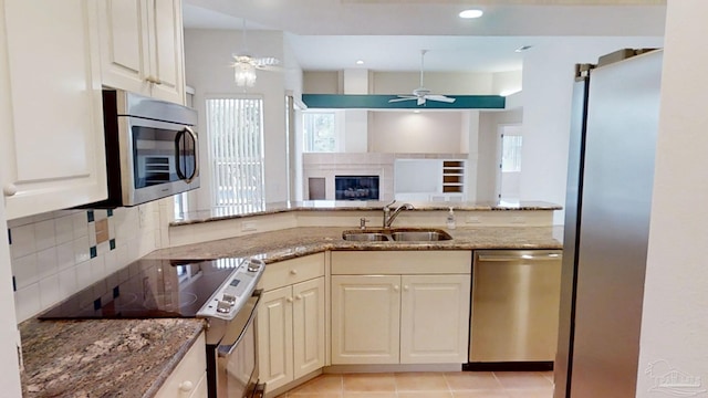 1129 Seabreeze Ln, Gulf Breeze, FL 32563 - kitchen featuring decorative backsplash, ceiling fan, light stone countertops, appliances with stainless steel finishes, and a sink