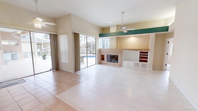 1129 Seabreeze Ln, Gulf Breeze, FL 32563 - unfurnished living room featuring a fireplace with flush hearth, a healthy amount of sunlight, baseboards, and a ceiling fan