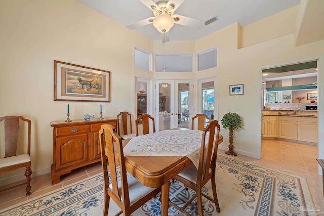 dining room with ceiling fan, light tile patterned floors, sink, and a high ceiling