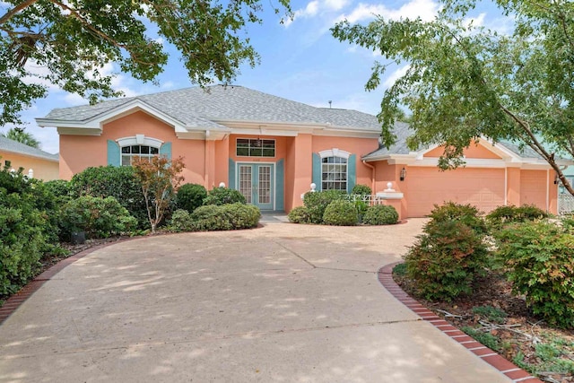 1129 Seabreeze Ln, Gulf Breeze, FL 32563 - view of front of home with french doors, a garage, driveway, and stucco siding