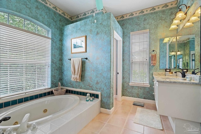 bathroom with tiled bath, vanity, and tile patterned flooring