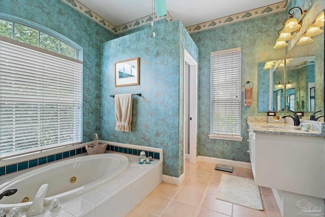 1129 Seabreeze Ln, Gulf Breeze, FL 32563 - bathroom with tile patterned floors, vanity, a tub with jets, baseboards, and wallpapered walls