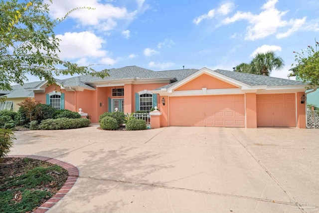 view of front of property with an attached garage, driveway, and stucco siding