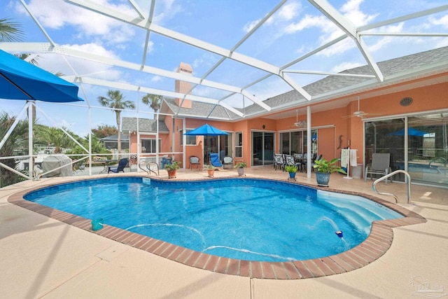 view of pool with ceiling fan, a patio, and a lanai